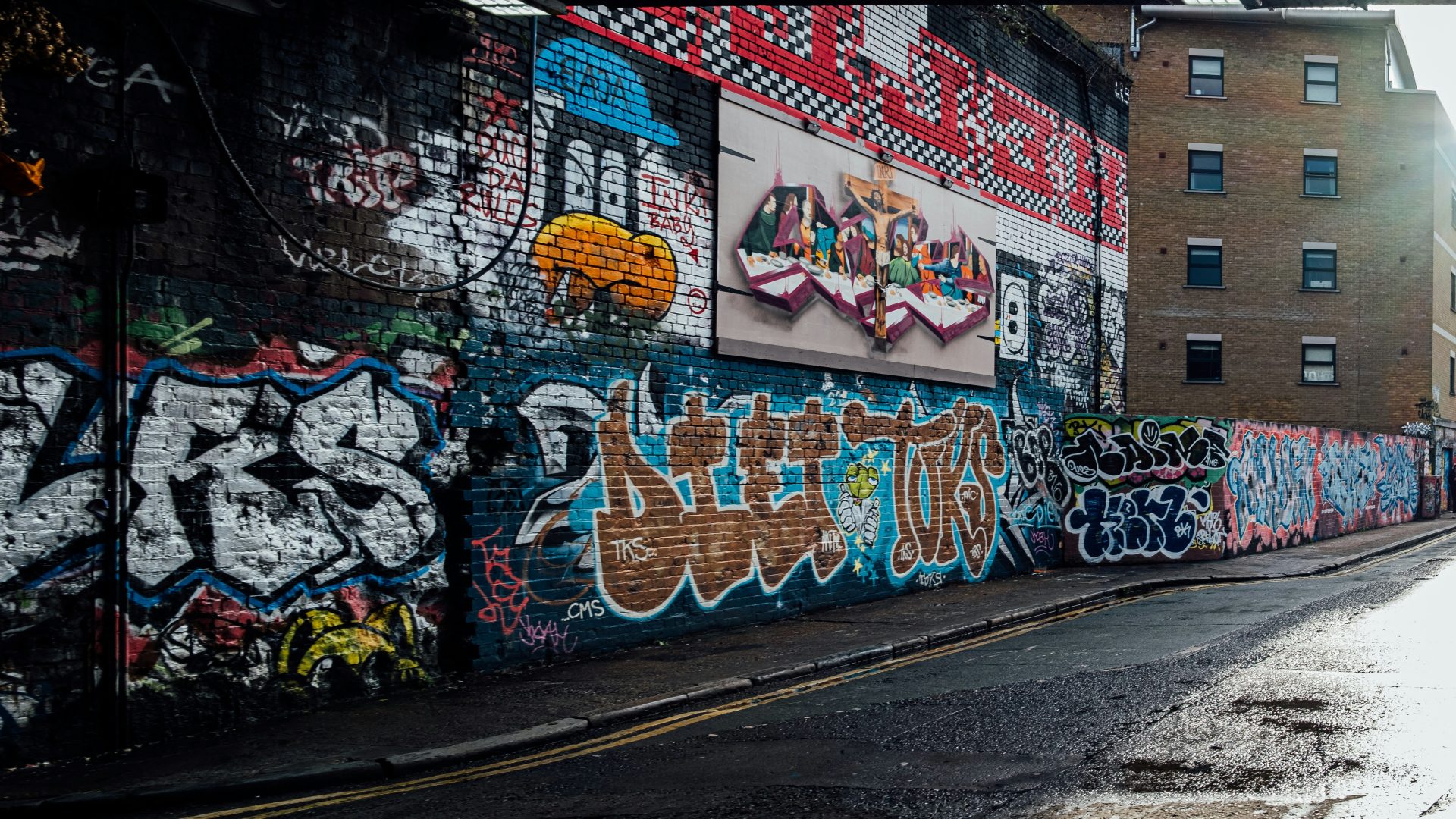 a city street with a wall covered in graffiti
